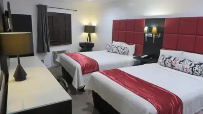 a hotel room with two beds and a red headboard at Legend Hotel Hollywood in Los Angeles