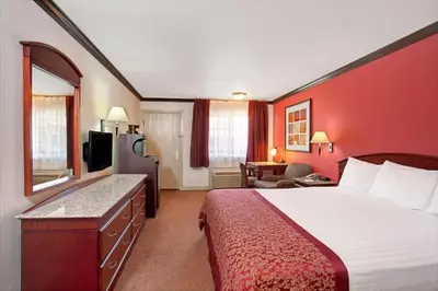 a hotel room with a bed and a television at Ramada by Wyndham Pasadena in Pasadena