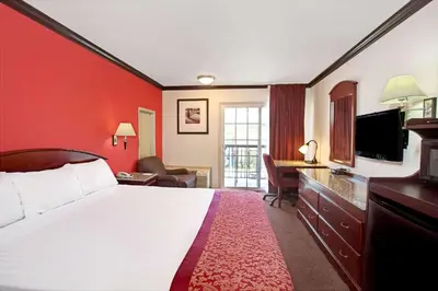 a hotel room with a bed and a television at Ramada by Wyndham Pasadena in Pasadena