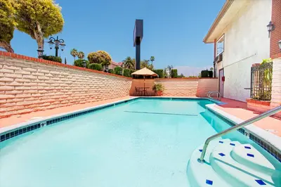 a swimming pool with a brick wall at Ramada by Wyndham Pasadena in Pasadena