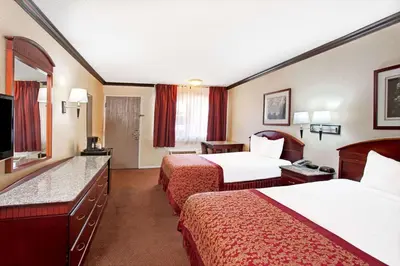 a hotel room with two beds and a television at Ramada by Wyndham Pasadena in Pasadena
