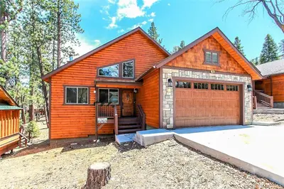 a wooden house with a garage in front of it at Alpine Chalet-1840 by Big Bear Vacations in Big Bear Lake