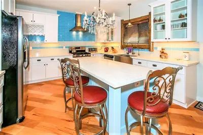a kitchen with a large white island with red chairs at Alpine Chalet-1840 by Big Bear Vacations in Big Bear Lake