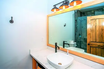 a bathroom with a sink and a large mirror at Alpine Chalet-1840 by Big Bear Vacations in Big Bear Lake