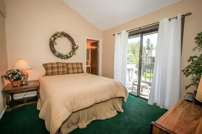a bedroom with a bed with a mirror and a balcony at Boulder Creek-1412 by Big Bear Vacations in Big Bear Lake
