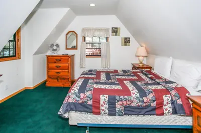 a bedroom with a bed and a dresser and a window at Breezy Estate-114 by Big Bear Vacations in Big Bear Lake