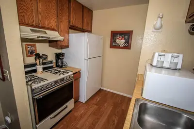 a kitchen with a stove and a white refrigerator at Boulder Creek -1417 by Big Bear Vacations in Big Bear Lake