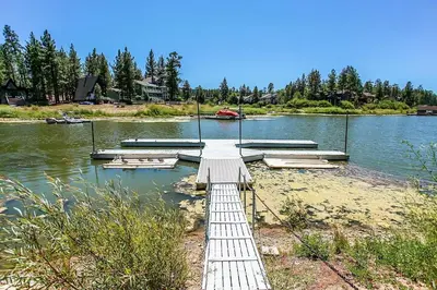 a dock on a lake with a boat in the water at Breezy Two-113 by Big Bear Vacations in Big Bear Lake