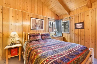 a bedroom with a bed in a wooden cabin at Oriole Cottage-621 by Big Bear Vacations in Big Bear Lake