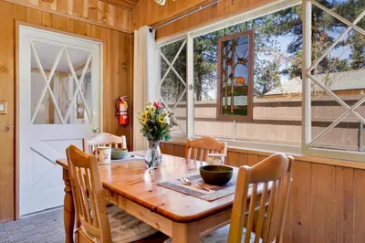 a dining room with a wooden table and a window at Oriole Cottage-621 by Big Bear Vacations in Big Bear Lake