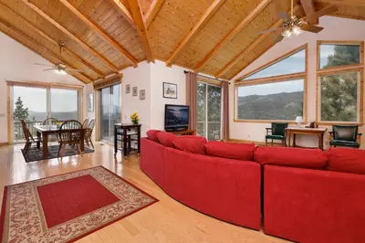 a living room with a red couch and a table at Starlight Vistas-1524 by Big Bear Vacations in Big Bear Lake