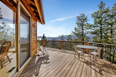 a wooden deck with a table and chairs on it at Starlight Vistas-1524 by Big Bear Vacations in Big Bear Lake