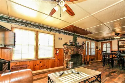 a living room with a ceiling fan and a stone fireplace at Frank's Old Bear-149 by Big Bear Vacations in Big Bear Lake