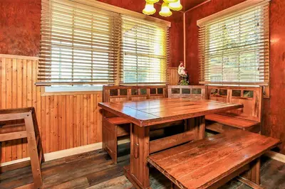 a dining room with a wooden table and benches at Frank's Old Bear-149 by Big Bear Vacations in Big Bear Lake
