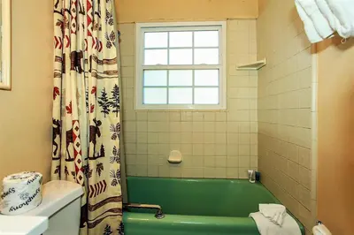 a bathroom with a green tub and a window at Frank's Old Bear-149 by Big Bear Vacations in Big Bear Lake