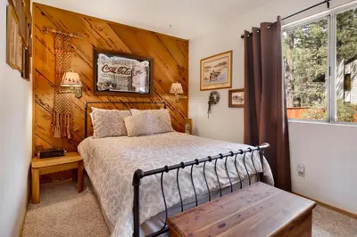 a bedroom with a bed and a wooden wall at Popko's Place Resort Chalet by Big Bear Vacations in Big Bear Lake