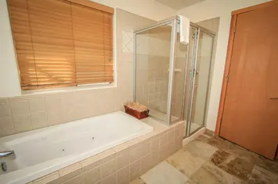 a bathroom with a tub and a glass shower at Can't Bear to Leave-1156 by Big Bear Vacations in Big Bear Lake