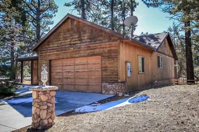 a small wooden building with a garage at Can't Bear to Leave-1156 by Big Bear Vacations in Big Bear Lake
