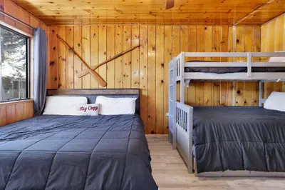 two bunk beds in a room with wooden walls at Shore Acres Lodge-450 by Big Bear Vacations in Big Bear Lake