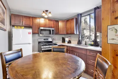 a kitchen with a wooden table and a table and chairs at Shore Acres Lodge-450 by Big Bear Vacations in Big Bear Lake