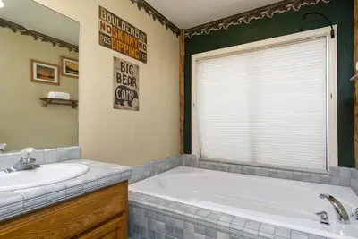 a bathroom with a tub and a sink at Lake Shore Family Cabin w Hot Tub and Pool Table by Big Bear Vacations in Big Bear Lake