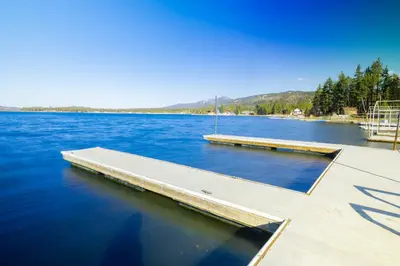 a dock in the middle of a large body of water at Lake Shore Family Cabin w Hot Tub and Pool Table by Big Bear Vacations in Big Bear Lake