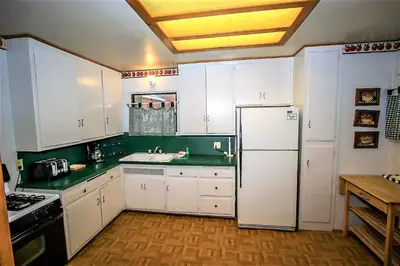 a kitchen with white cabinets and a refrigerator at Kelley's Kabin-290 by Big Bear Vacations in Big Bear Lake