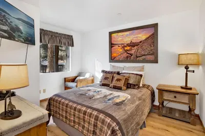 a bedroom with a bed and a table with a chair at Ski Time Getaway-1848 by Big Bear Vacations in Big Bear Lake