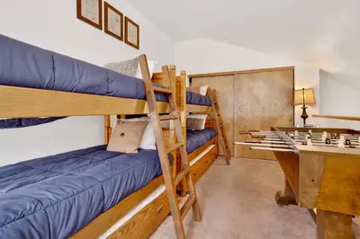 a room with three bunk beds and a desk at Ski Time Getaway-1848 by Big Bear Vacations in Big Bear Lake