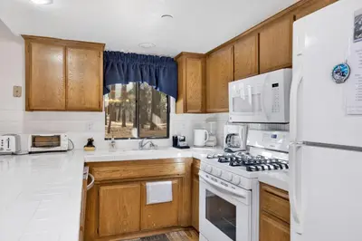 a kitchen with white appliances and wooden cabinets at Ski Time Getaway-1848 by Big Bear Vacations in Big Bear Lake