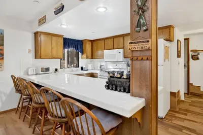 a kitchen with a white counter top and wooden cabinets at Ski Time Getaway-1848 by Big Bear Vacations in Big Bear Lake