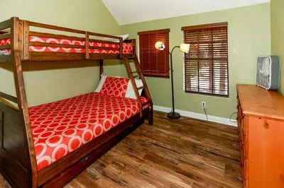 a bedroom with a bunk bed with red comforter at Fawnskin Chalet-1826 by Big Bear Vacations in Fawnskin