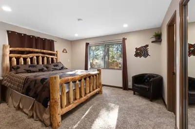 a bedroom with a wooden bed and a chair at Mountain Fun-1729 by Big Bear Vacations in Big Bear Lake