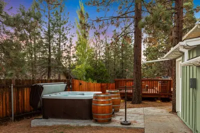 a hot tub in a yard next to a fence at Mountain Fun-1729 by Big Bear Vacations in Big Bear Lake