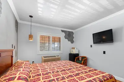 a bedroom with a bed and a flat screen tv at Beverly Inn in Los Angeles