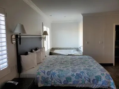a bedroom with a bed and a tub in it at Ocean Surf Inn & Suites in Huntington Beach