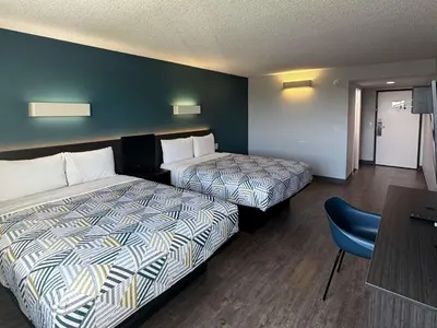 a hotel room with two beds and a table at Motel 6-Carson, CA in Carson