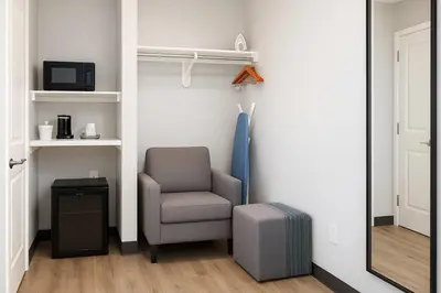 a room with a chair and a mirror at Travelodge by Wyndham LAX in El Segundo