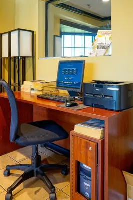 an office with a desk with a computer and a printer at Ramada by Wyndham Ontario Airport & Convention Center in Ontario
