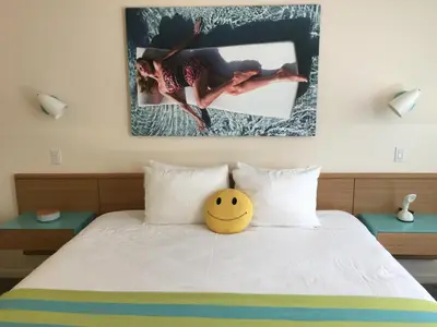 a bed with a yellow smiley ball on it at The Beverly Laurel Hotel at West Hollywood in Los Angeles