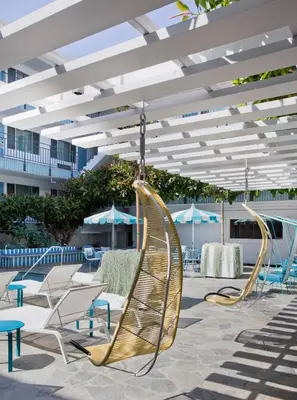 a group of chairs and umbrellas on a patio at The Beverly Laurel Hotel at West Hollywood in Los Angeles
