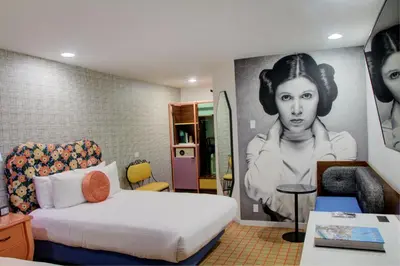 a room with a bed and a painting of a woman at The Hollywood Franklin Hotel near Universal Studios in Los Angeles