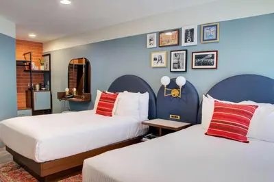 two beds in a room with blue walls at The Hollywood Franklin Hotel near Universal Studios in Los Angeles