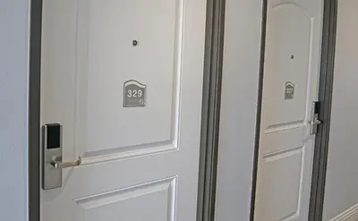 a white door with a clock on it at Surf City Inn in Huntington Beach
