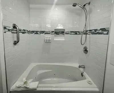 a white bath tub in a bathroom with a shower at The Pacific Inn in Seal Beach