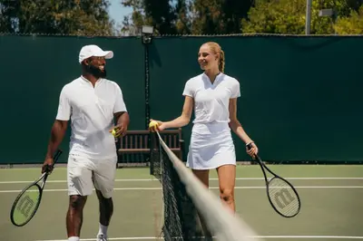 a man and a woman shaking hands on a tennis court at Luxe Sunset Boulevard Hotel in Los Angeles