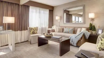 a living room with a couch and a table at Luxe Sunset Boulevard Hotel in Los Angeles