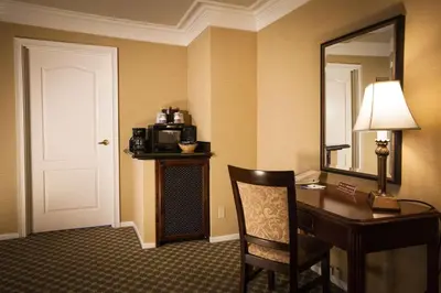 a hotel room with a desk and a mirror at Best Western Plus Sunset Plaza Hotel in Los Angeles
