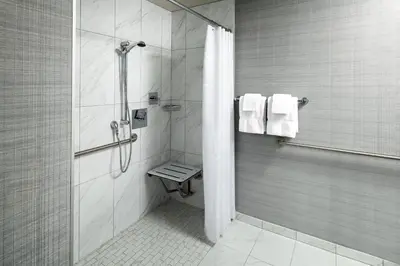 a bathroom with a shower and a toilet and towels at Sheraton Grand Los Angeles in Los Angeles