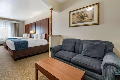 a hotel room with a bed and a couch at Citrus Suites Redlands Loma Linda Hotel in Redlands